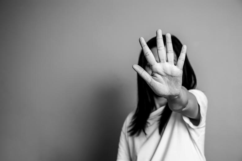 Woman with raised hand in front of her face